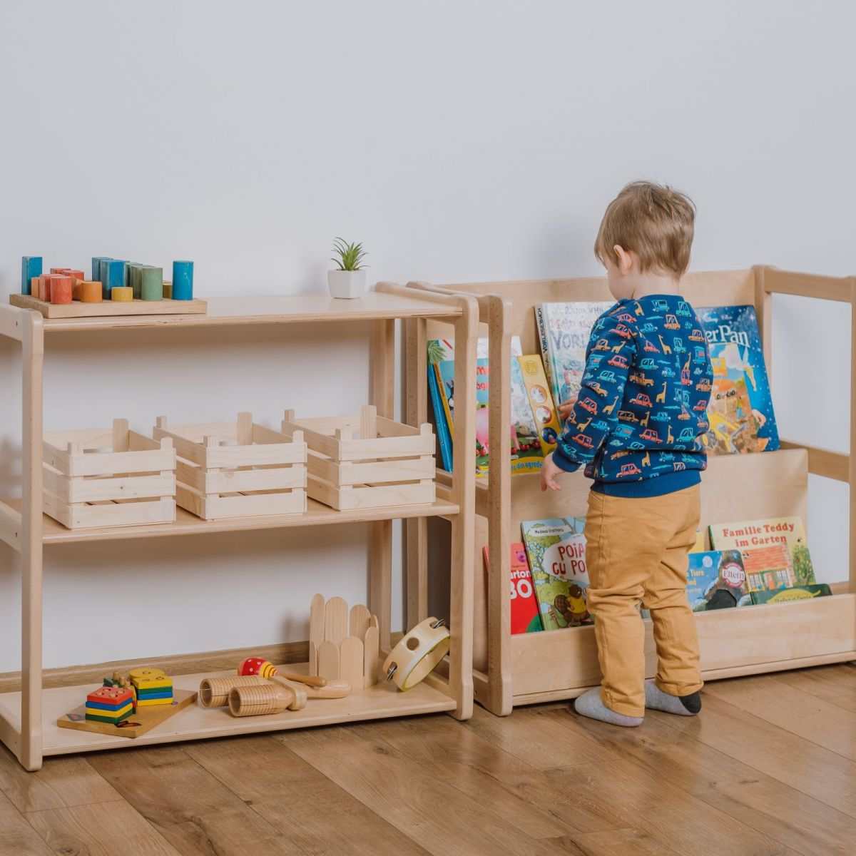 Montessori-inspired children&#39;s bookshelf and mini shelf set with child selecting a book.