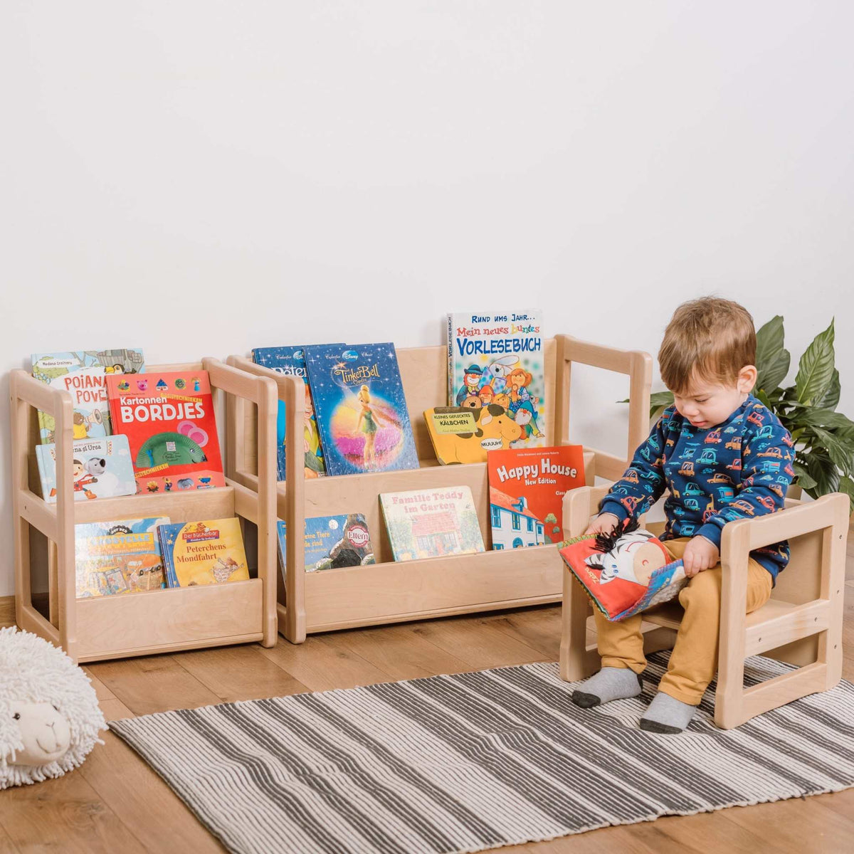 Montessori-inspired mini bookshelf for children, with books and child reading, made of FSC-certified wood.