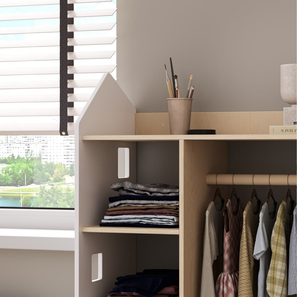 White open children&#39;s wardrobe in house shape for Montessori-style organization, featuring accessible shelving and hanging space.