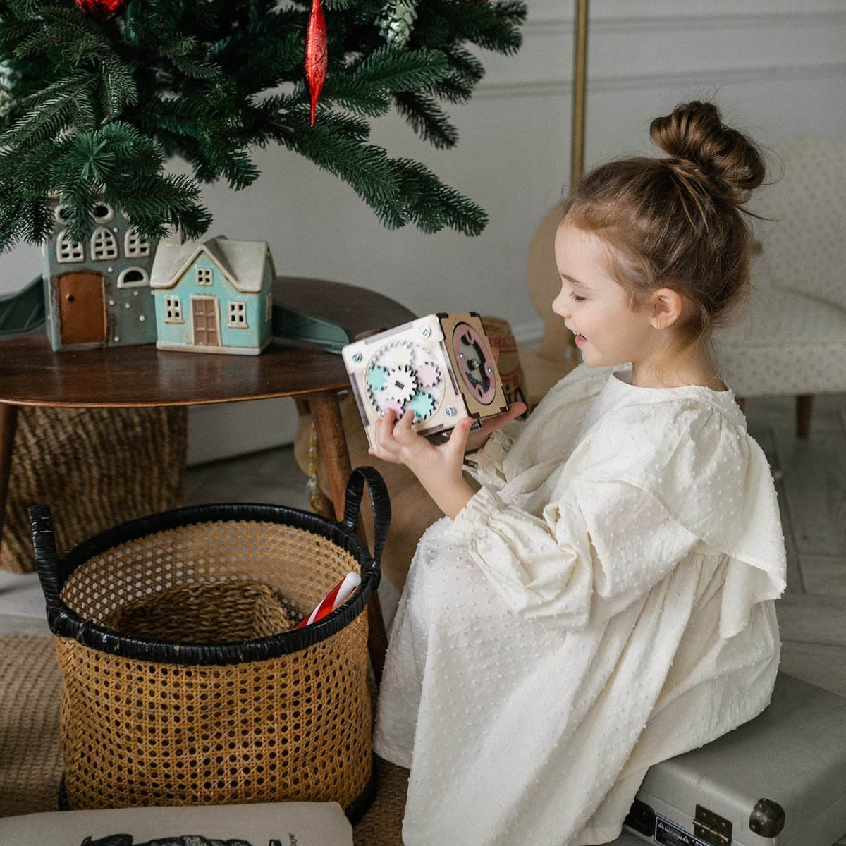 Child playing with a Kreativer Würfel under a Christmas tree.