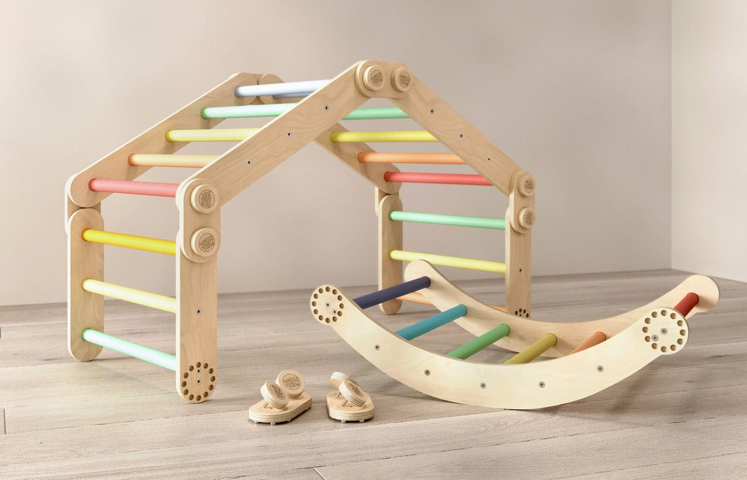 Rainbow-colored children&#39;s climbing frame set with swing, featuring adjustable Pikler triangles, made of birch wood for indoor play.