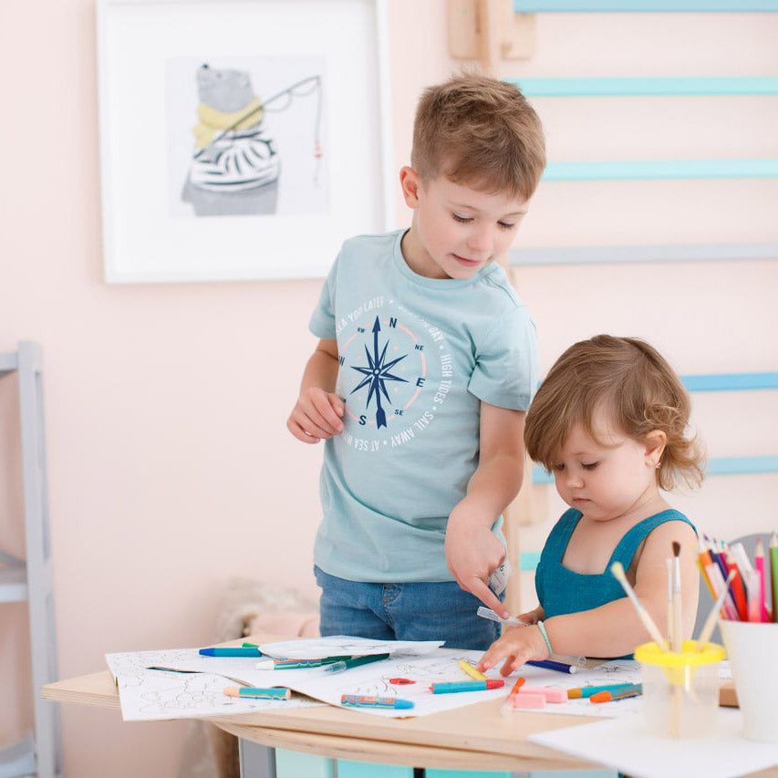 Kids playing with art supplies at a table.