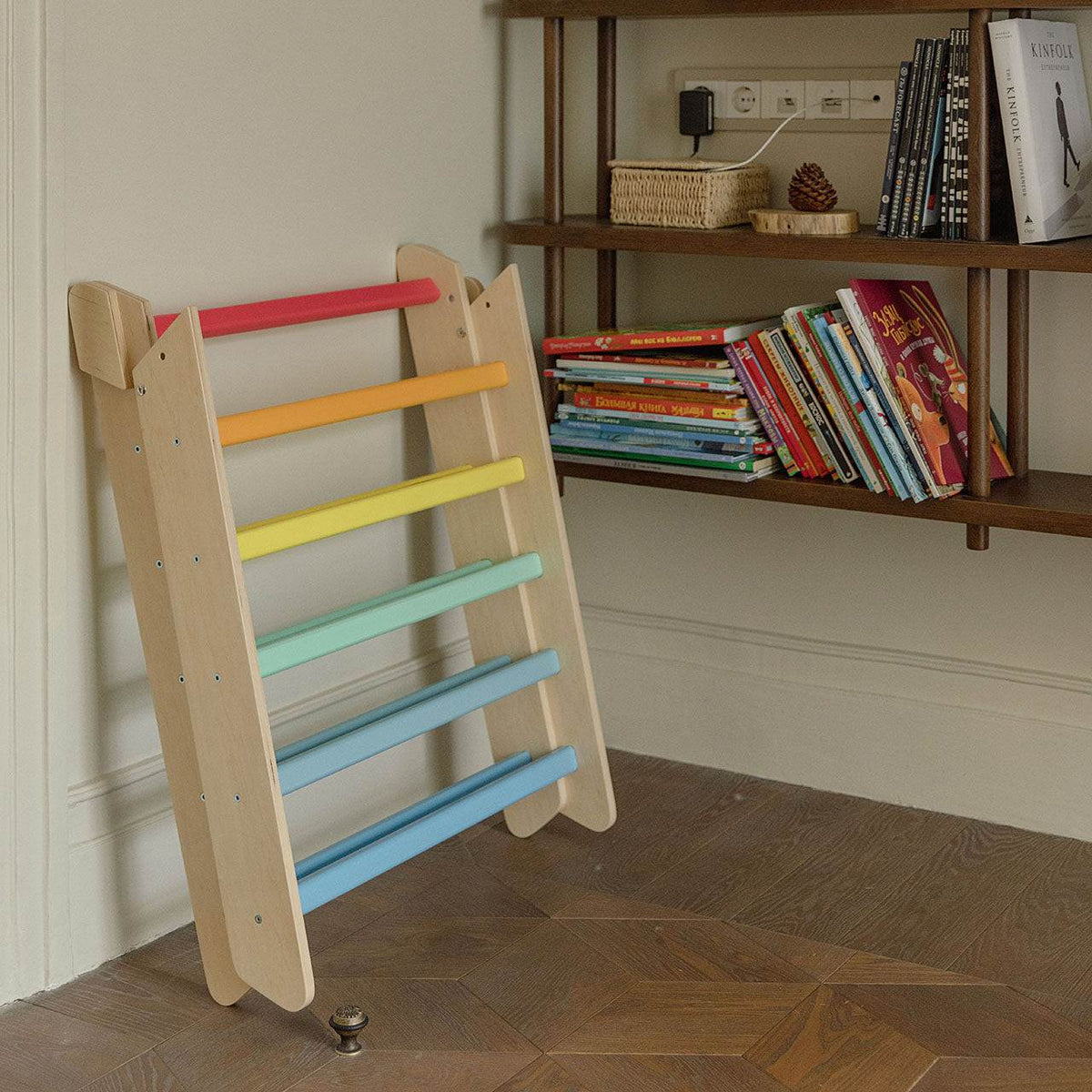 Colorful Kletterdreieck wooden climbing triangle for kids, featuring sturdy rainbow rungs for safe play indoors.