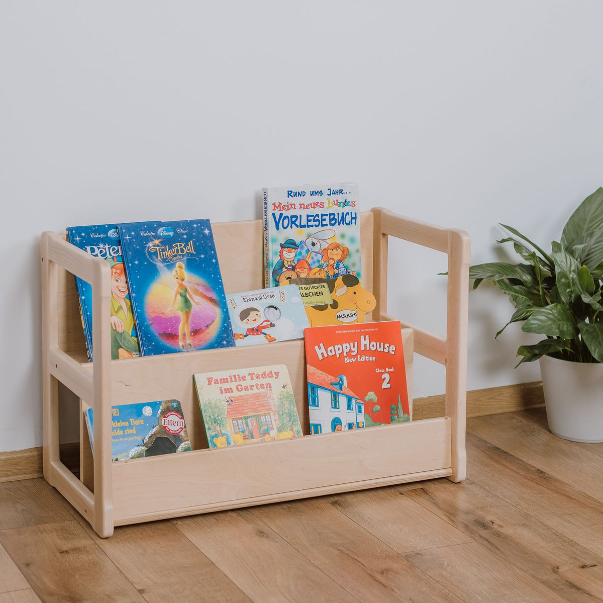 Montessori-inspired mini bookshelves for children ages 12 months and up, showcasing book covers for easy selection; made from FSC-certified beech, solid wood frames, and birch plywood shelves.