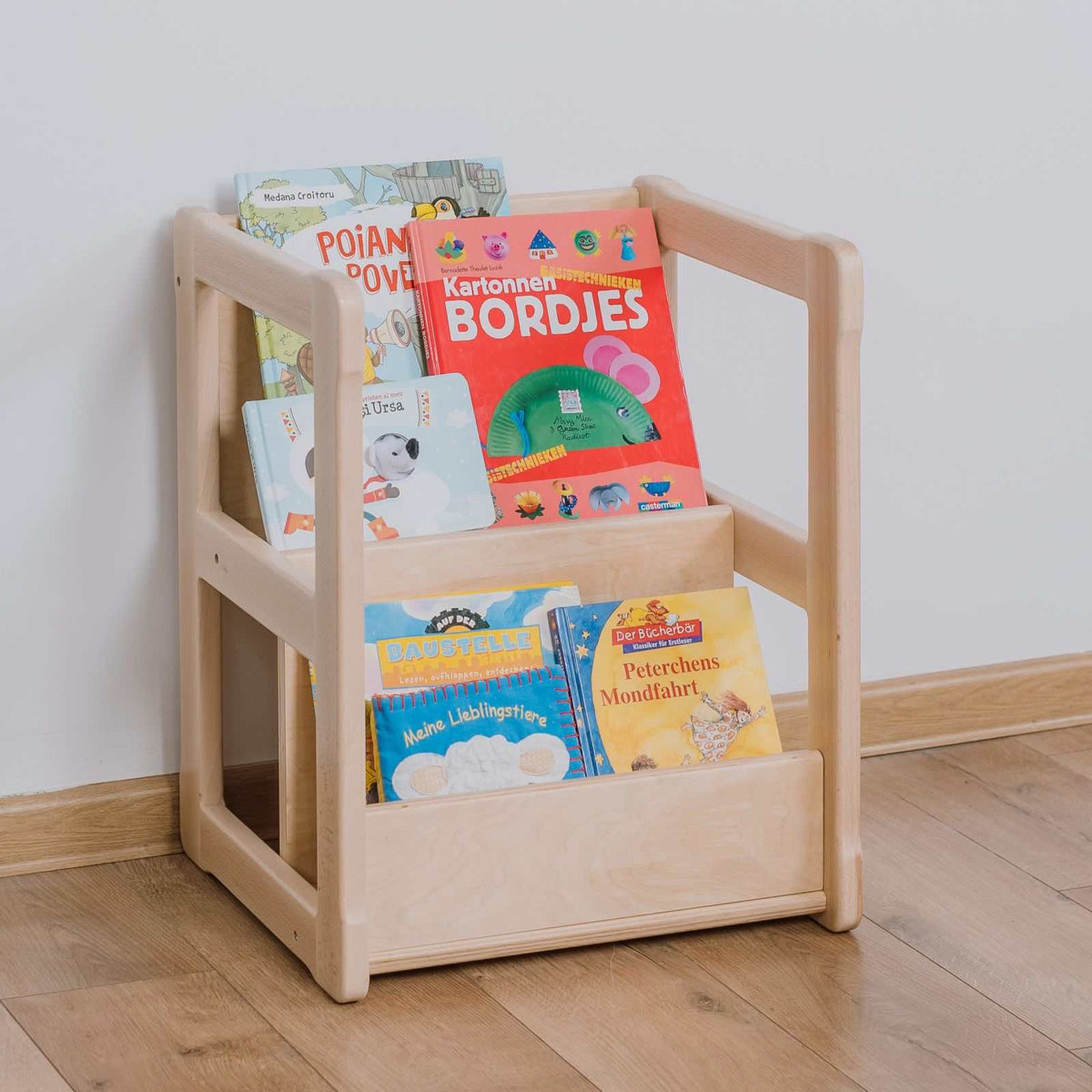 Small wooden Bücherregal displaying children&#39;s books, ideal for easy selection and access.