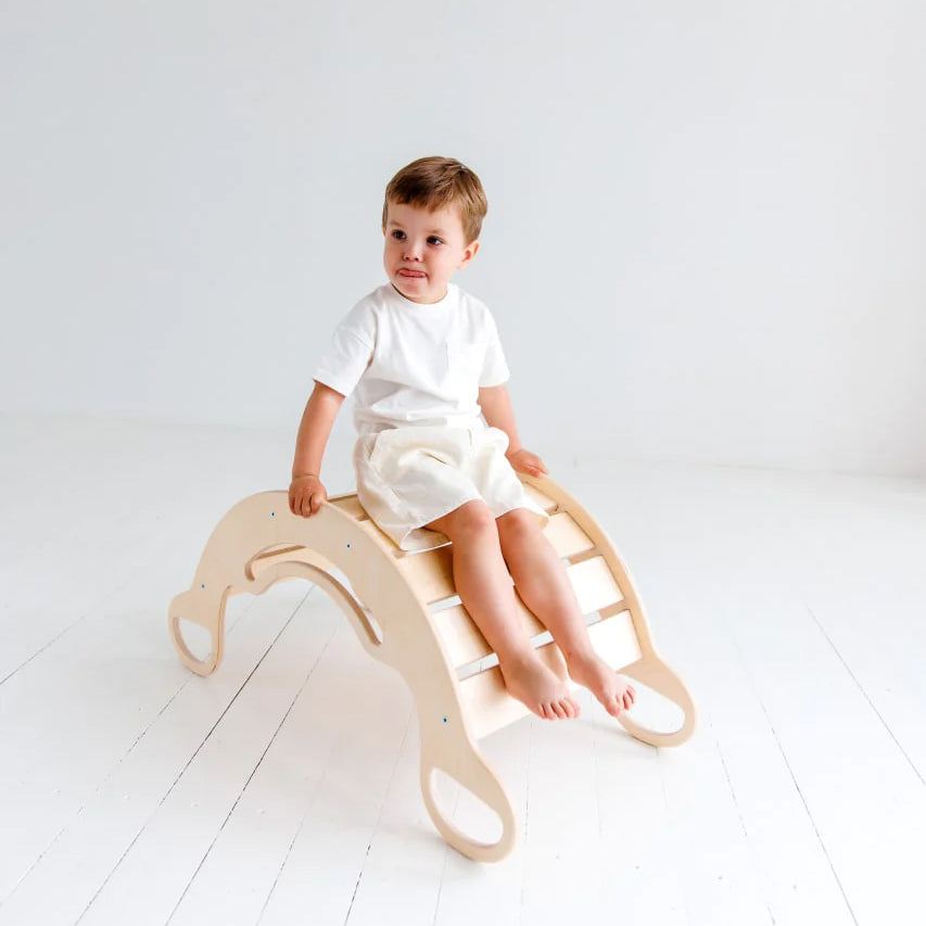 Child enjoying Balancewippe/Rocker Schaukel made of natural birch plywood for active play and exercise.