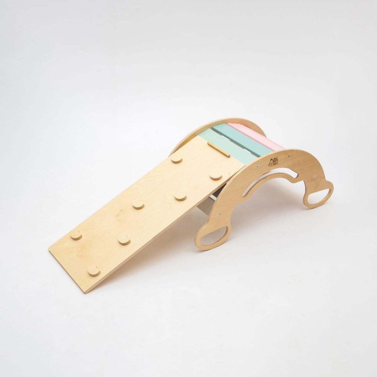 Balance rocker with double-sided pastel board for children&#39;s motor skills development.