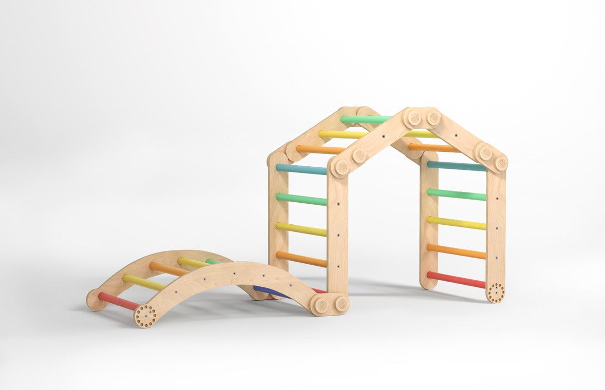 Rainbow-colored children&#39;s climbing frame set with a swing, featuring two Pikler triangles made of durable birch wood.