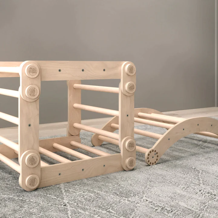 Children&#39;s natural wooden climbing frame set with swing on carpet.