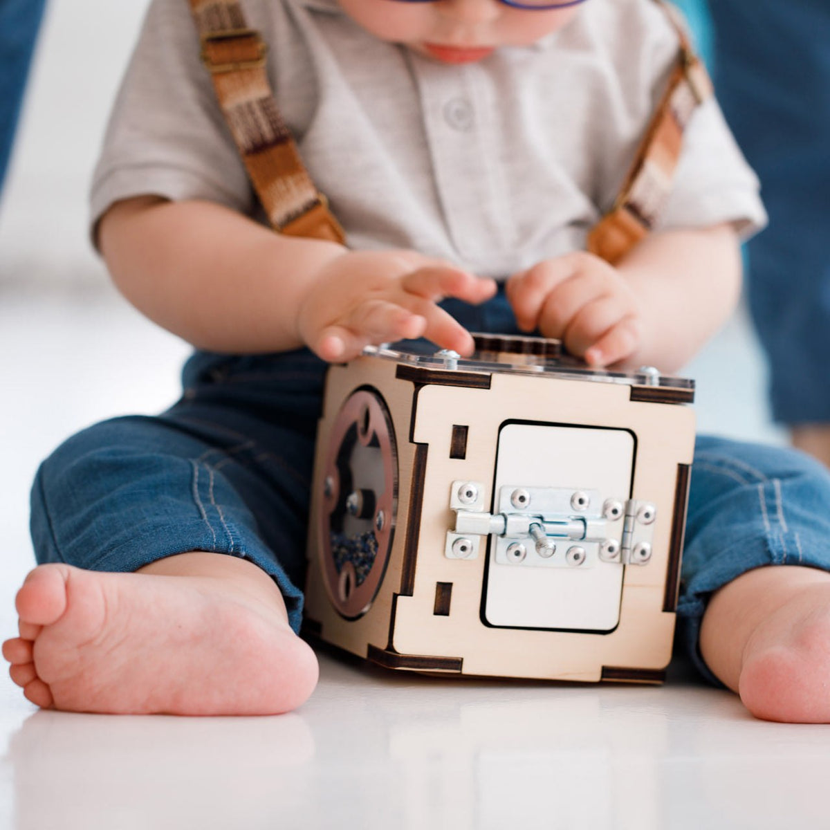 Baby playing with a creative wooden activity cube.