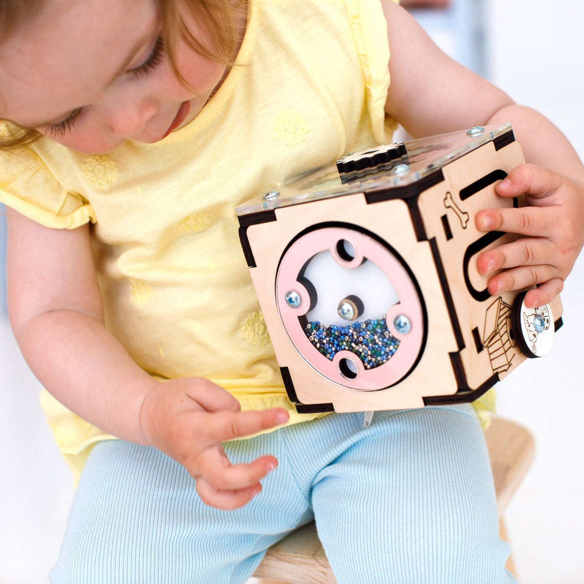 Wooden interactive learning cube for babies and toddlers, featuring multiple activity panels for motor skills and cognitive development.
