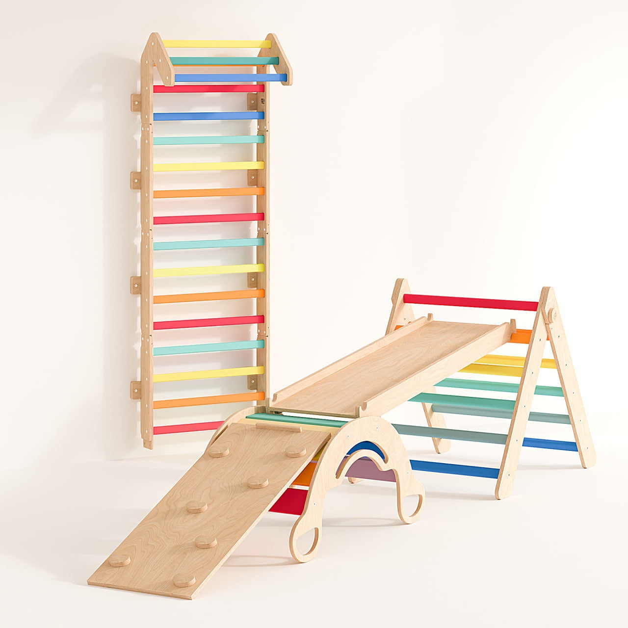 Rainbow-colored indoor play set with climbing wall, Pikler triangle, slides, and balance rocker for kids.
