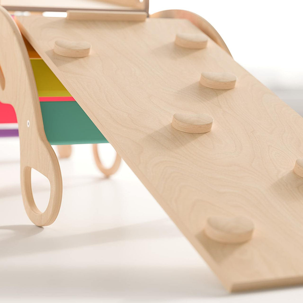 Multi-purpose indoor playground set featuring a rainbow-colored Pikler triangle, reversible ramps, balance rocker, and climbing wall for children.