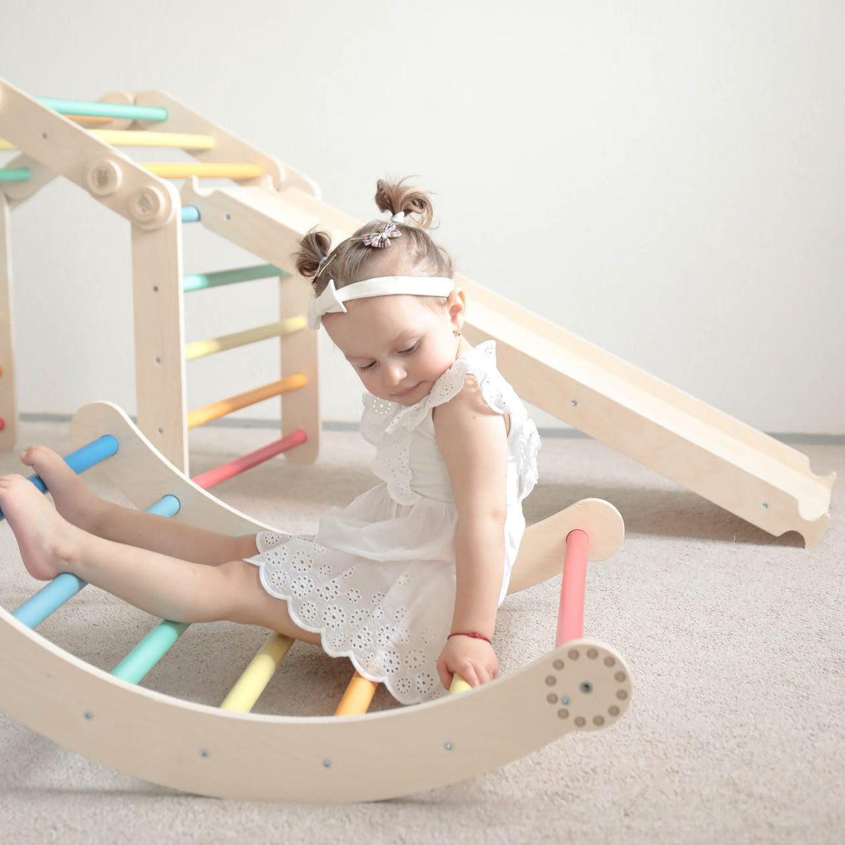 Colorful children&#39;s climbing frame set with slide and swing, featuring a child playing.