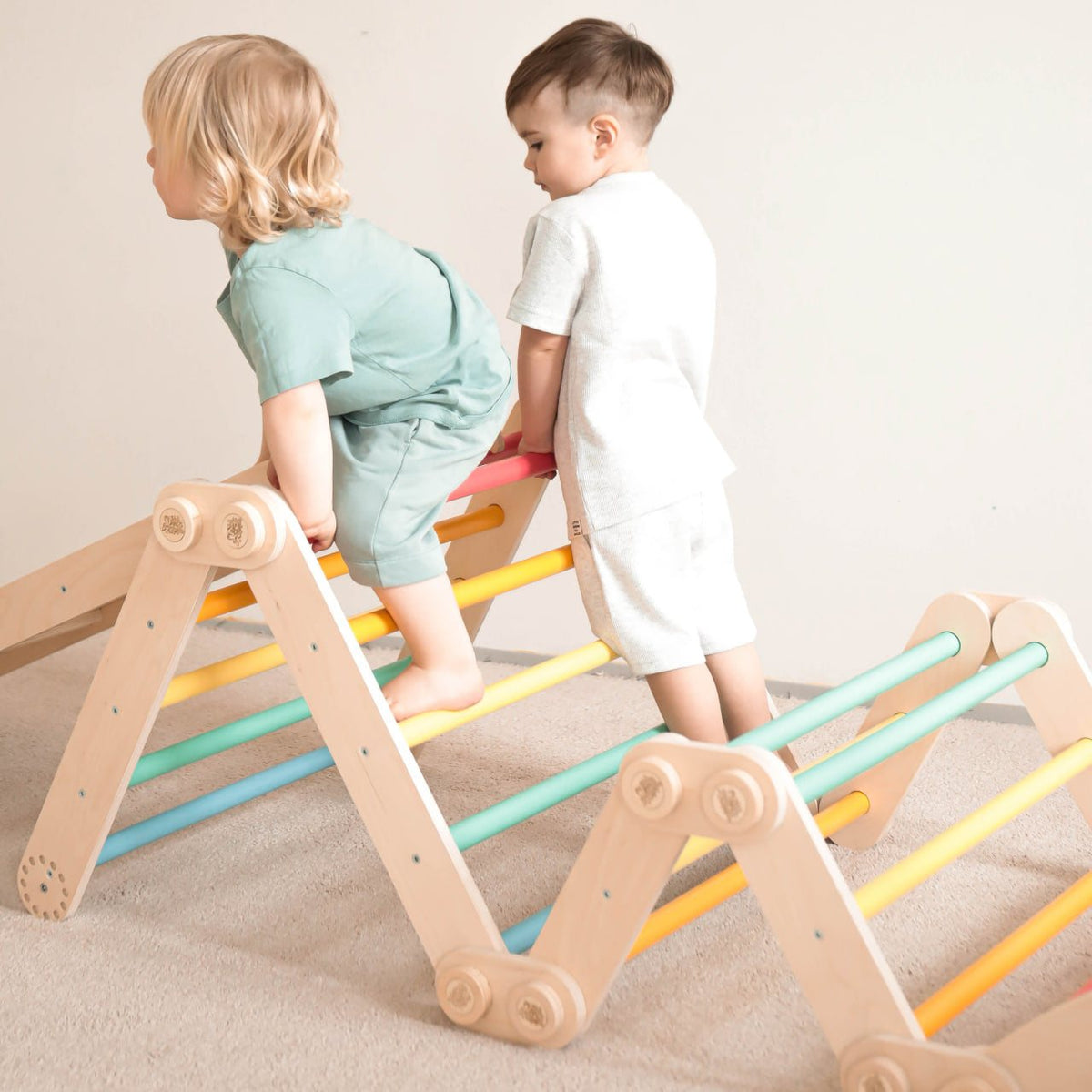 Children climbing on a colorful wooden Maxi climbing frame set.