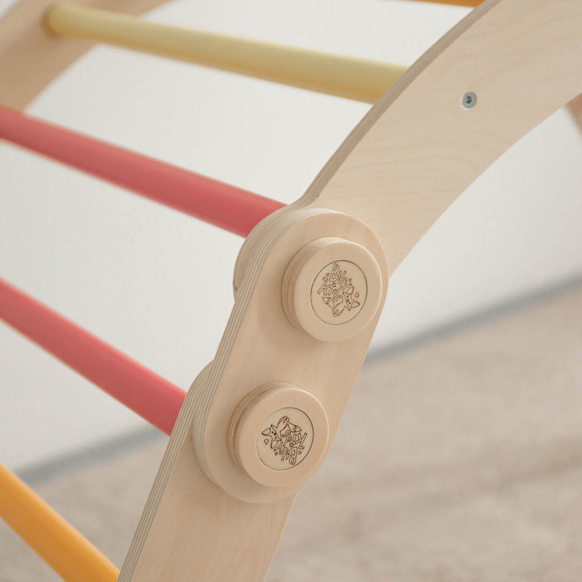 Children&#39;s rainbow climbing frame set with swing made from birch wood.