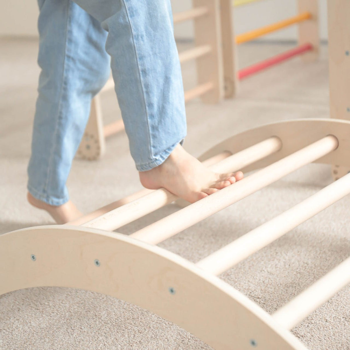 Child climbing on a natural wooden play set.