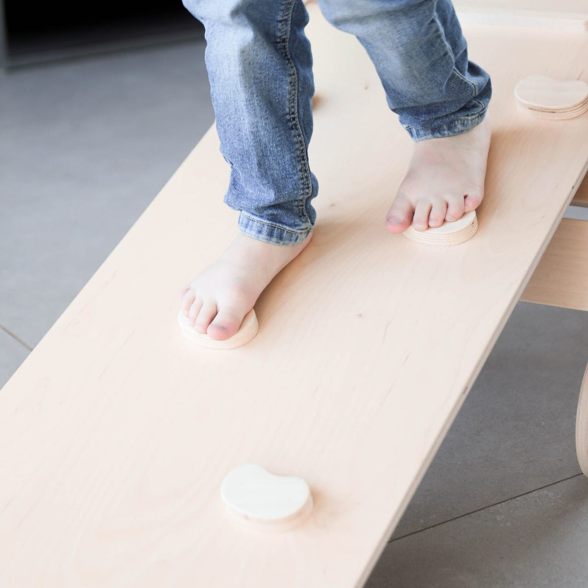 child balancing on a Pikler triangle board from the natural wooden set